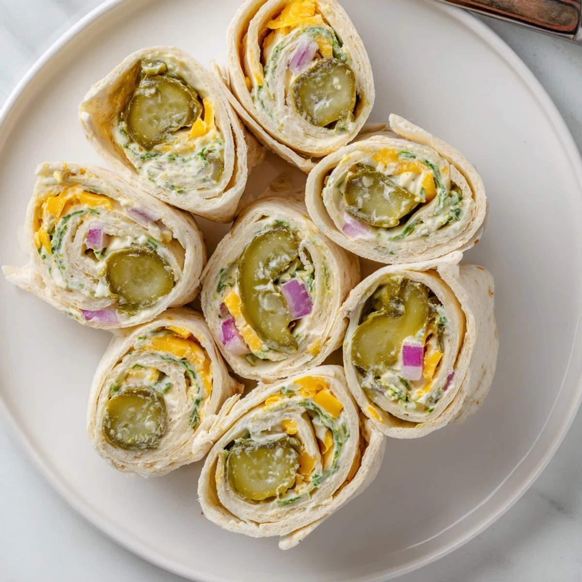 Crisp dill pickle wrapped in creamy cheese and soft tortilla, Pickle-in-a-Blanket delight.  