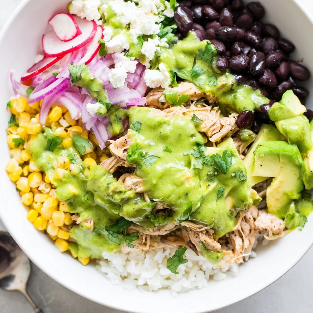 Delicious Green Enchiladas Rice Bowl topped with fresh avocado and queso fresco.  