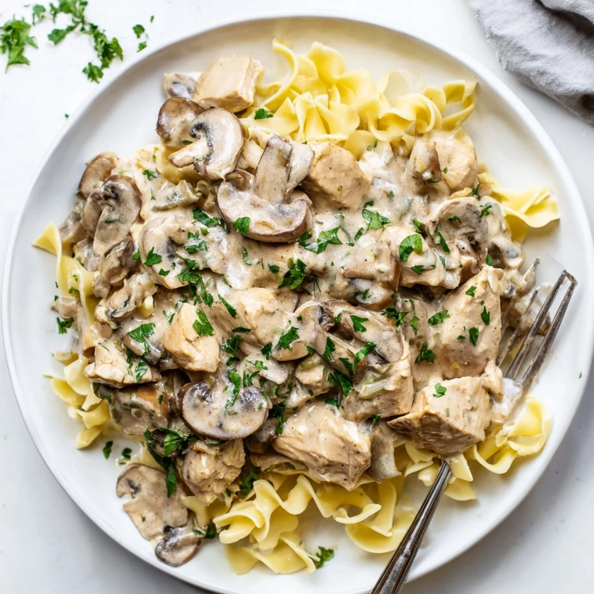 Creamy Chicken Stroganoff served over buttery egg noodles, topped with fresh parsley.  
