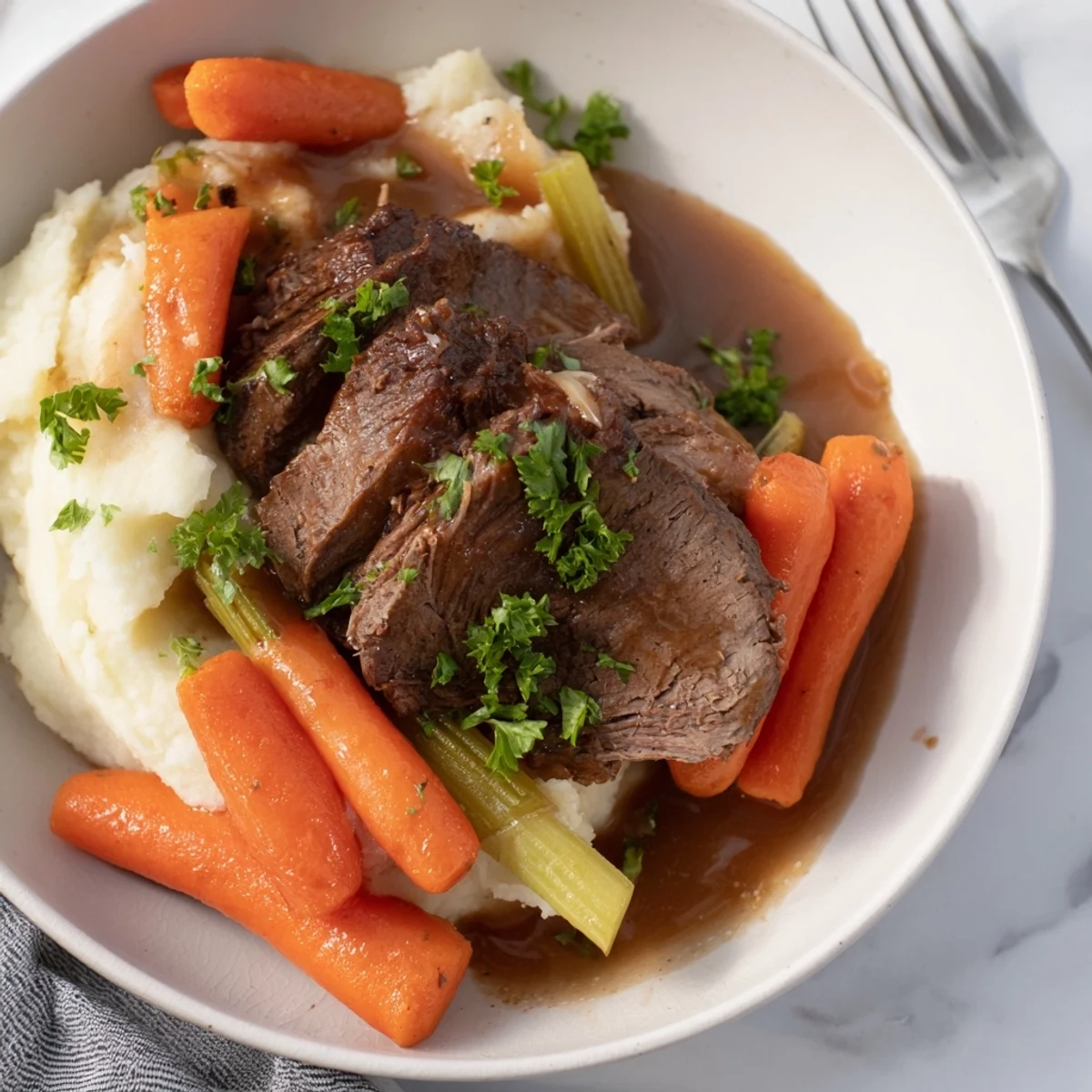 Creamy mashed potatoes alongside juicy Slow Cooker Pot Roast, an ideal dinner for any family.