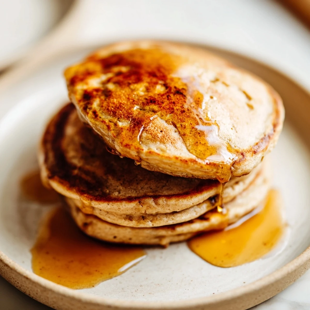 Golden, fluffy Protein Banana Pancakes, ready to be topped with fresh berries and enjoyed.