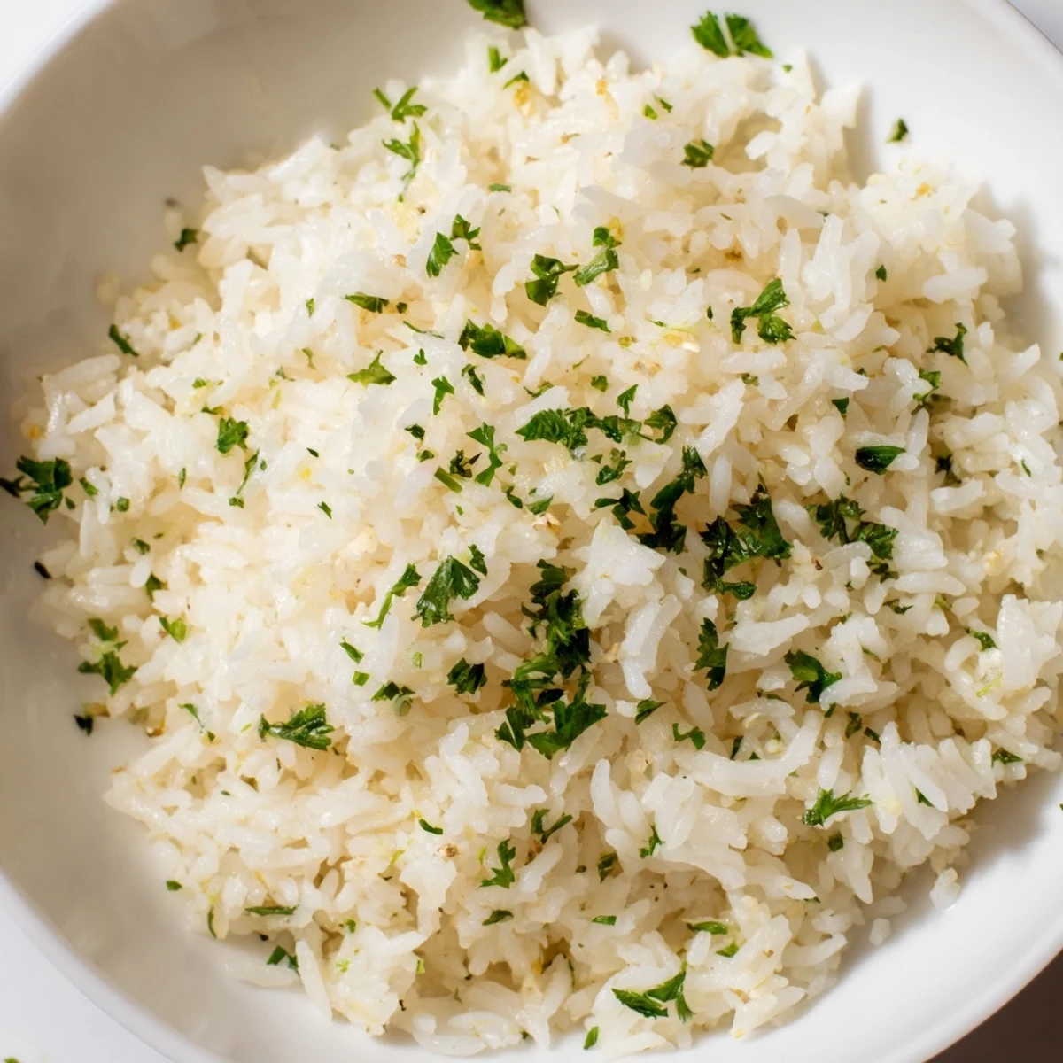 Fluffy, golden Garlic Butter Rice, ready to serve and glistening with melted butter and fresh parsley.