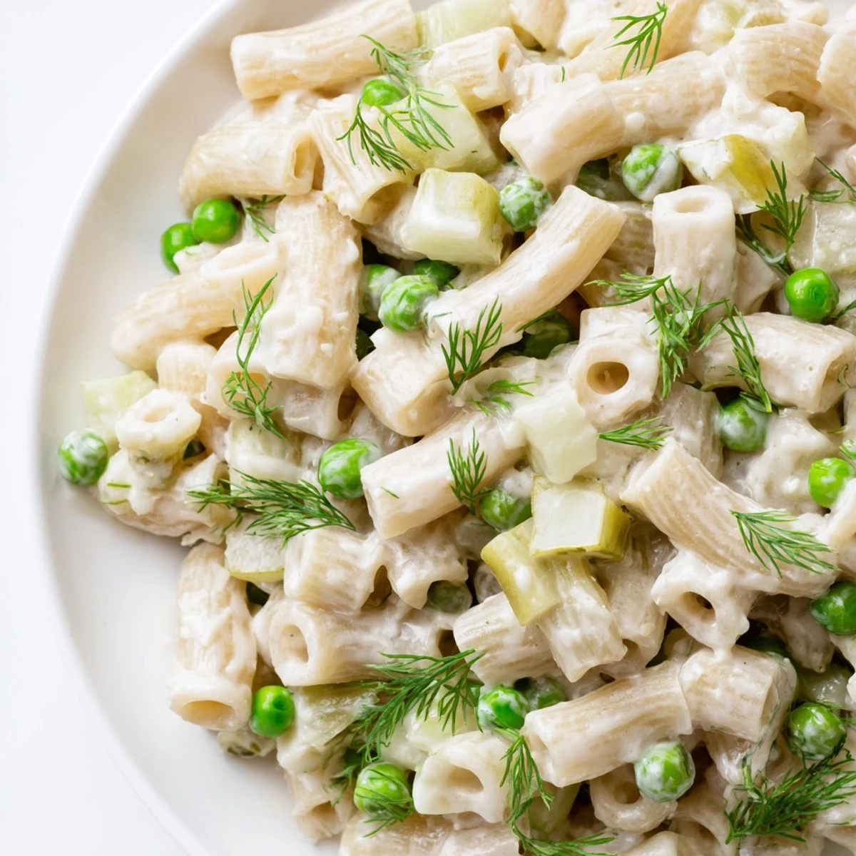 A bright bowl of Creamy Dill Pickle Pasta Salad, garnished with fresh dill and perfect alongside grilled chicken or sandwiches.