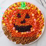 This festive Jack-o-Lantern Candy Board features a sweet pumpkin face, perfect for a Halloween party snack.