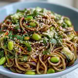 The finished Soba Noodle Bowl presents chewy buckwheat noodles, fresh vegetables, and herbs, ready to be enjoyed as a refreshing light meal.  