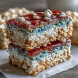 Chewy, colorful Rice Krispies squares with vibrant red, white, and blue layers for Independence Day dessert.