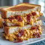 Close-up of classic pimento cheese spread on soft white bread, cut into elegant finger sandwiches for afternoon tea.