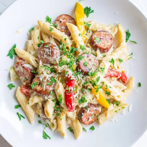 Cajun Spiced Smoked Sausage Alfredo: a steaming bowl of creamy pasta with savory sausage and fresh parsley.