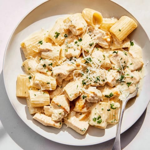 Delicious Creamy Garlic Parmesan Chicken Rigatoni drizzled with extra cheese and herbs.  