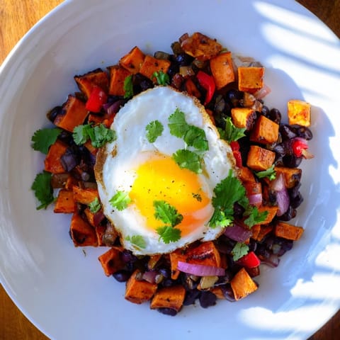 Sizzling skillet of Sweet Potato & Black Bean Breakfast Hash: a colorful, flavorful American breakfast dish.