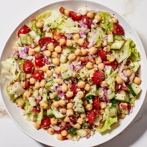 This La Scala Chopped Chickpea Salad shows a vibrant bowl with chopped crisp vegetables and cheese.