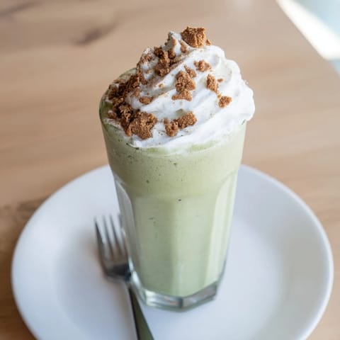 A layered shot showcases the creamy Sugar-Free Gingerbread Cookie Matcha Frappe, a festive sugar-free beverage.