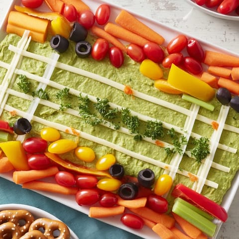 A delicious Game Day Football Field Snack Board with colorful dips, chips, and fresh veggie sticks.