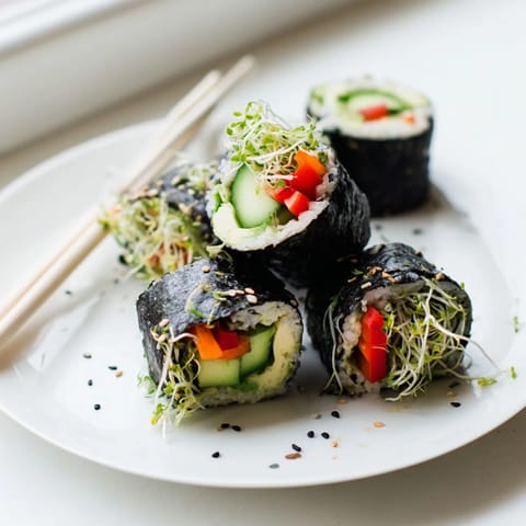 Sliced Nori Rolls with Vegetables arranged on a bamboo mat, highlighting the vibrant carrot, bell pepper, and avocado fillings inside the roasted seaweed.
