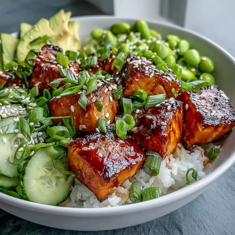 Overhead view of a colorful Salmon Rice Bowl with baked salmon, jasmine rice, cucumber, avocado, and sesame seeds.